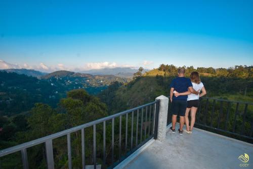 een man en vrouw op een balkon met uitzicht op de bergen bij Cozy Cottage Ella in Ella