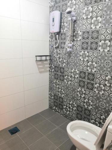 a bathroom with a shower and a toilet at Orkid Apartment in Cameron Highlands