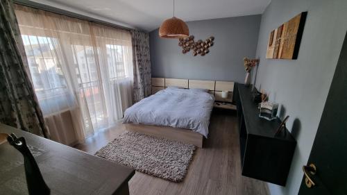1 dormitorio con cama, escritorio y ventana en Râșnov Loft, en Râșnov