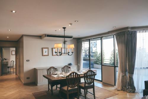 a dining room with a table and chairs and a dining room at THEA Private Suites by TH District in Bangkok