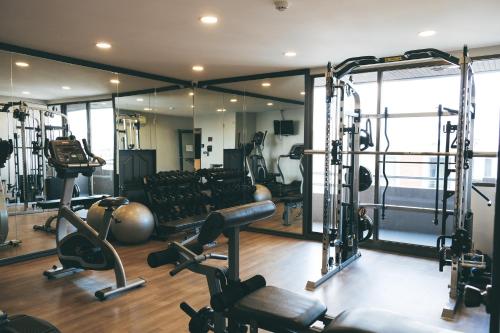 a gym with several treadmills and weights at THEA Private Suites by TH District in Bangkok