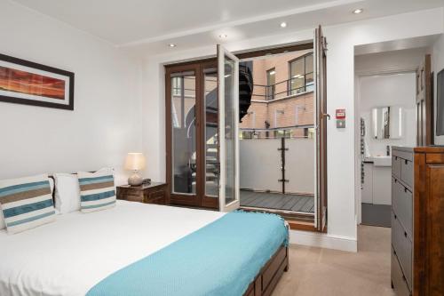 a bedroom with a large bed and a balcony at Apartment 4, 48 Bishopsgate by City Living London in London