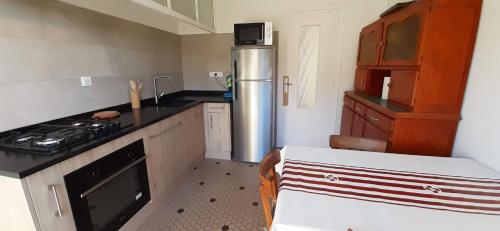 Il comprend une cuisine équipée d'un réfrigérateur en acier inoxydable et d'une cuisinière. dans l'établissement La maison de Maritxu - Entre plage et foret - Landes - Pays Basque, à Tarnos