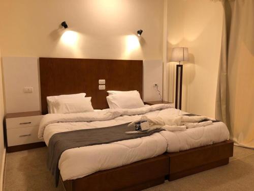 a bedroom with a large bed with white sheets at Sphinx Luxor Apartment in Luxor