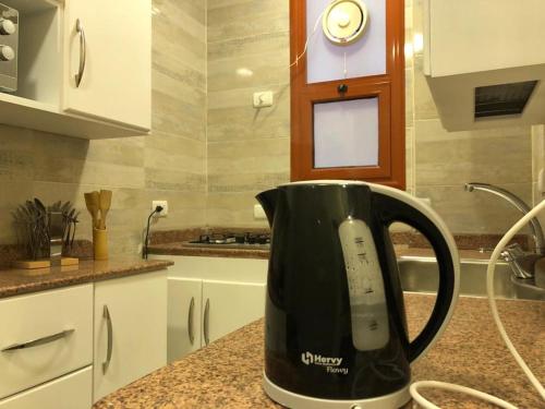 a black coffee pot sitting on a counter in a kitchen at Sphinx Luxor Apartment in Luxor
