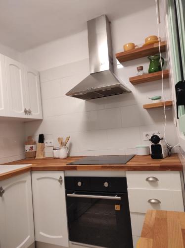 a kitchen with white cabinets and a black stove top oven at Cal Sabater in Preixana
