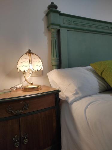 a lamp on a night stand next to a bed at Cal Sabater in Preixana