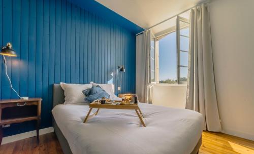 - une chambre bleue avec un lit et une table dans l'établissement Le Bel Endroit - Joli Studio vue jardin, à Bidache