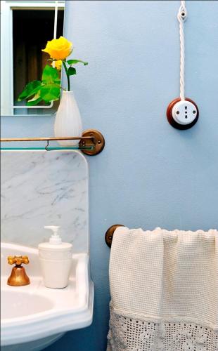 a bathroom with a sink and a clock on the wall at Bed and Breakfast Evelina in Lucca
