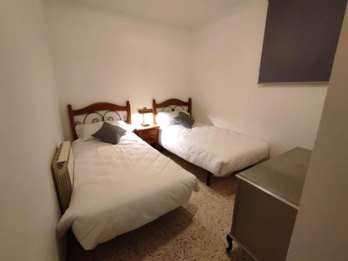 a bedroom with two beds and a desk with a night stand at Cal Sabater in Preixana