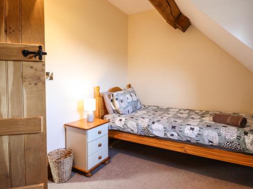 a bedroom with a bed and a night stand at The Old House in Llanidloes