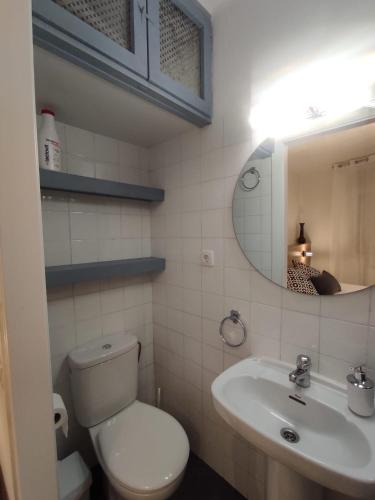 a bathroom with a toilet and a sink and a mirror at Cal Sabater in Preixana