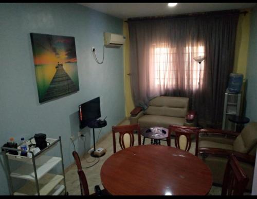 a living room with a table and a couch at XrisBun Apt 1BR - Laderin GRA in Abeokuta