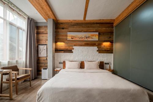 a bedroom with a bed and a wooden wall at Autumn Inn in Yangshuo