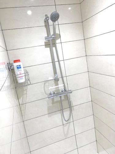 une douche avec pommeau de douche dans une salle de bain dans l'établissement Maison spacieuse à Volvic avec vue sur la montagne, à Volvic