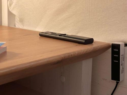 a remote control sitting on top of a wooden table at Ferienwohnung OutletCity in Metzingen
