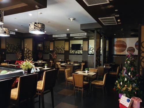 a restaurant with tables and chairs and a christmas tree at Amora NeoLuxe Suites Hotel in Bangkok