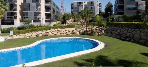 a swimming pool in a yard next to a building at Paradise Village Port Aventuras in Salou