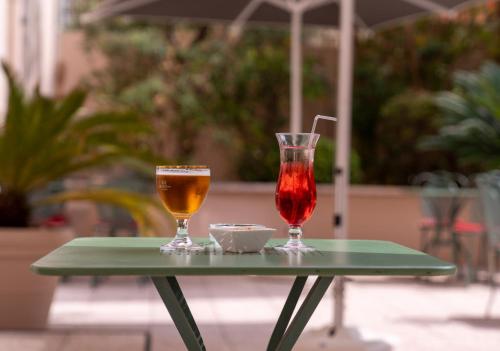 two drinks on a green table with an umbrella at easyHotel Nice Old Town in Nice