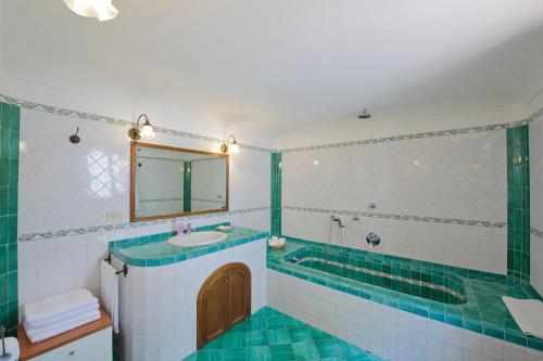 a bathroom with a tub and a sink and a mirror at Villa Aristide Amalfi Coast - POOL in Praiano