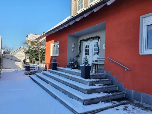 ein rotes Haus mit Treppe davor in der Unterkunft Lindner Ferienwohnungen und Doppelzimmer in Fichtelberg