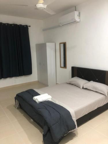 a bedroom with a large bed with two towels on it at Nara Homestay Serkam in Merlimau