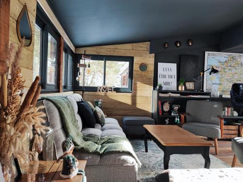 a living room with a couch and a table at Les Chalets Du Goulet in Le Bleymard