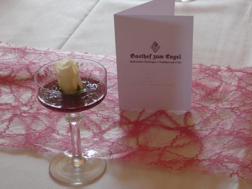 a glass of wine and a box on a table at Gasthof zum Engel in Dottingen
