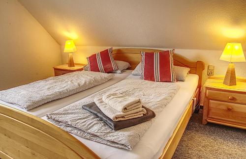 a bedroom with two beds with towels and two lamps at Ferienhaus Robbers mit 3 Schlafzimmer in Hatten