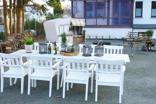 een witte tafel met witte stoelen en flessen wijn bij Ferienhaus Pier 1 in Ahlbeck