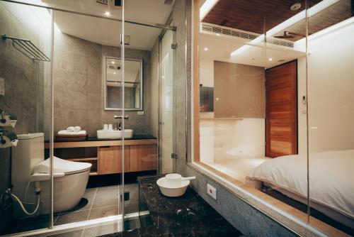 a bathroom with a tub and a toilet and a sink at Onsense Villa in Jiaoxi