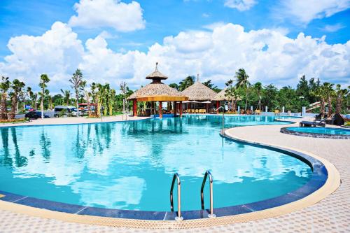 a large swimming pool at a resort with a gazebo at Muong Thanh Luxury Can Tho Hotel in Can Tho