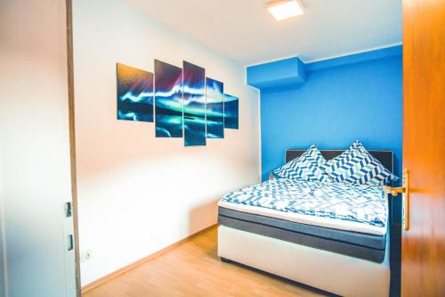 1 dormitorio con 1 cama con pared azul en Rheinterrasse Wohnung 1, en Lahnstein