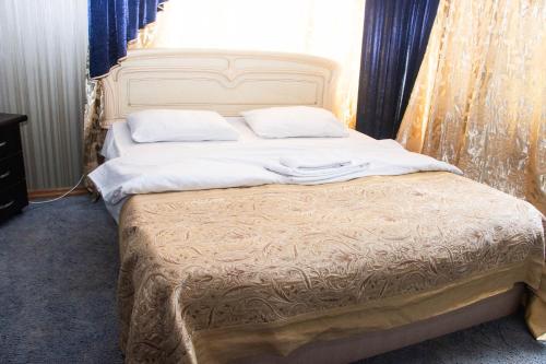 a bed with white sheets and pillows in a room at Hotel EZIO in Chişinău