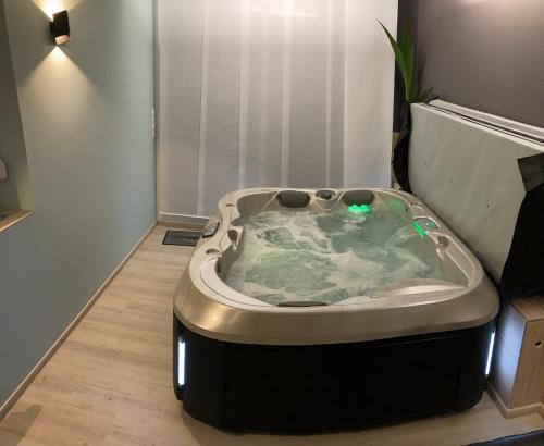 a jacuzzi tub in a corner of a room at La Victorine in Raismes