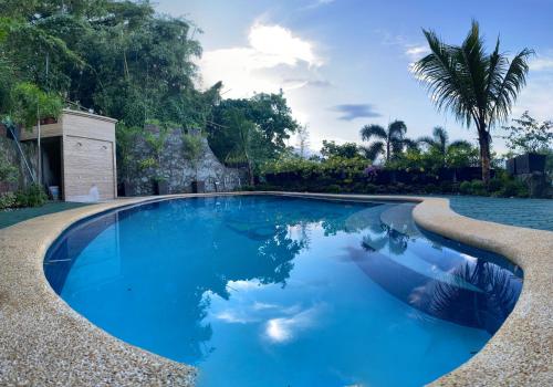 een zwembad met blauw water en palmbomen bij Pier Uno Dive Resort powered by Cocotel in Mabini