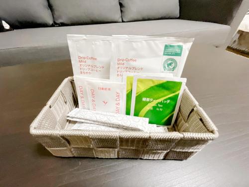 a basket with books and other items on a table at OUCHI HOTEL Otemachi in Hiroshima