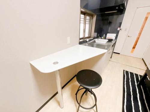 a white counter in a kitchen with a stool at OUCHI HOTEL Otemachi in Hiroshima