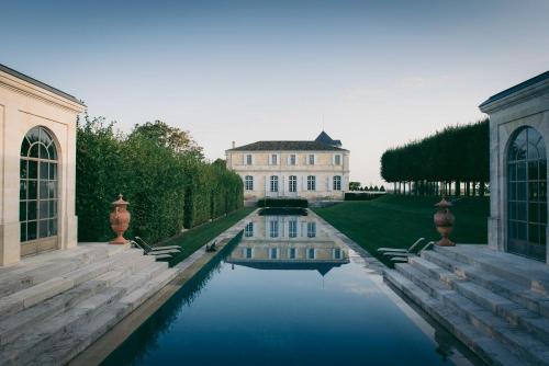 a house with a pool of water in front of it at Château du Tertre in Arsac