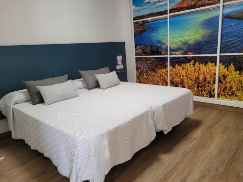 una camera da letto con un grande letto con due grandi finestre di Casa Cetáceo a Playa Quemada