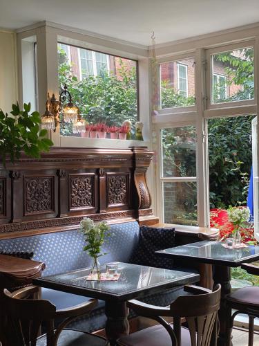 a restaurant with two tables and two windows at Frauenhotel Hanseatin - Women Only in Hamburg