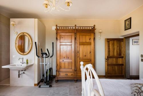 a bedroom with a bed and a sink and a mirror at Villa Eleonora in Lucignano