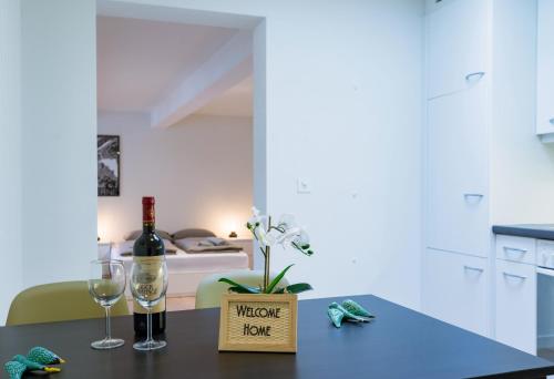 a table with a bottle of wine and two glasses at HITrental Zur Metzgern Apartments in Luzern