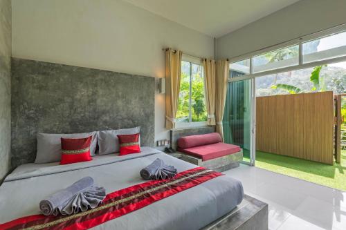 - une chambre avec un grand lit et une chaise rouge dans l'établissement Aonang Paradise Resort Krabi, à Ao Nang Beach