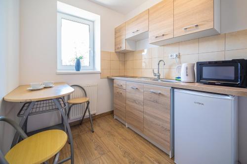 a small kitchen with a small table and a microwave at Penzión Čikovský in Stará Lesná