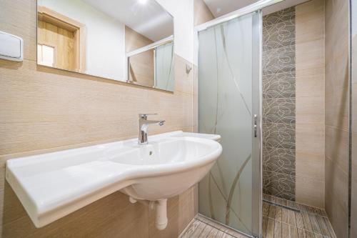 a bathroom with a sink and a shower at Penzión Čikovský in Stará Lesná