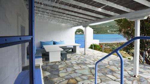 een veranda met een bank en uitzicht op de oceaan bij The charming Beach House, ideal for 4 to 5 people in Ioulida