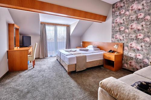 une chambre d'hôtel avec un lit et une télévision dans l'établissement Lugas Hotel, à Nyíregyháza