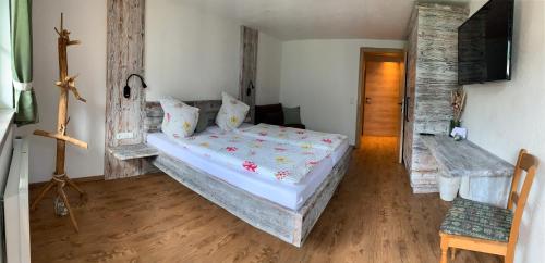 a bedroom with a bed and a wooden floor at Ferienhof Oberer Gollmitzer in Heiligenblut