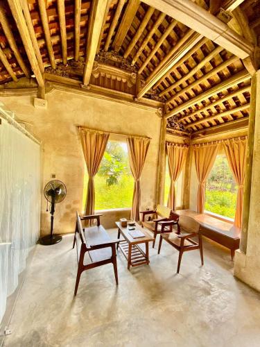 a living room with tables and chairs and a large window at HappyZen Farm in Vung Tau